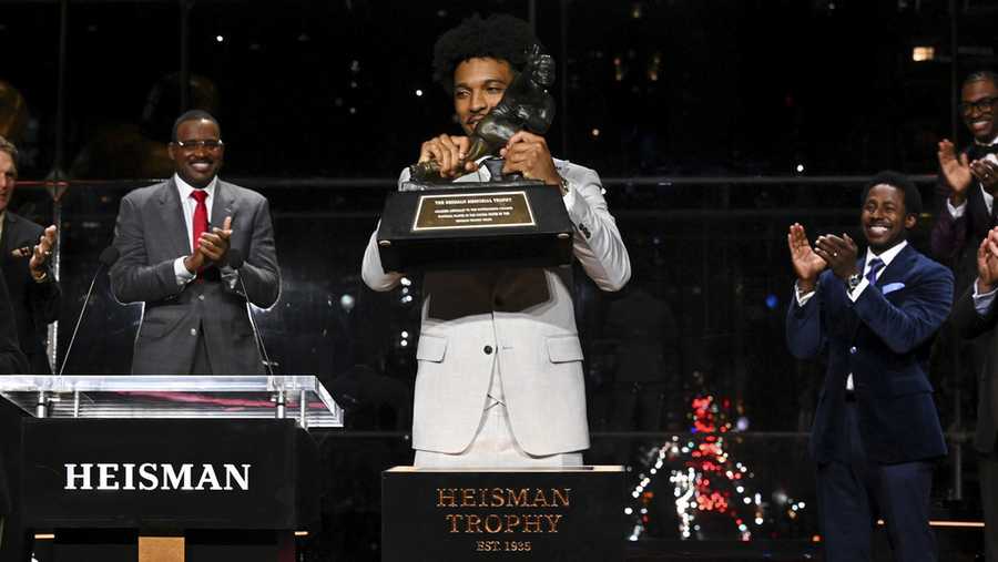LSU quarterback Jayden Daniels lifts Heisman Trophy after winning the college football award, Saturday, Dec. 9, 2023, in New York. (Todd Van Emst/Pool Photo via AP)
